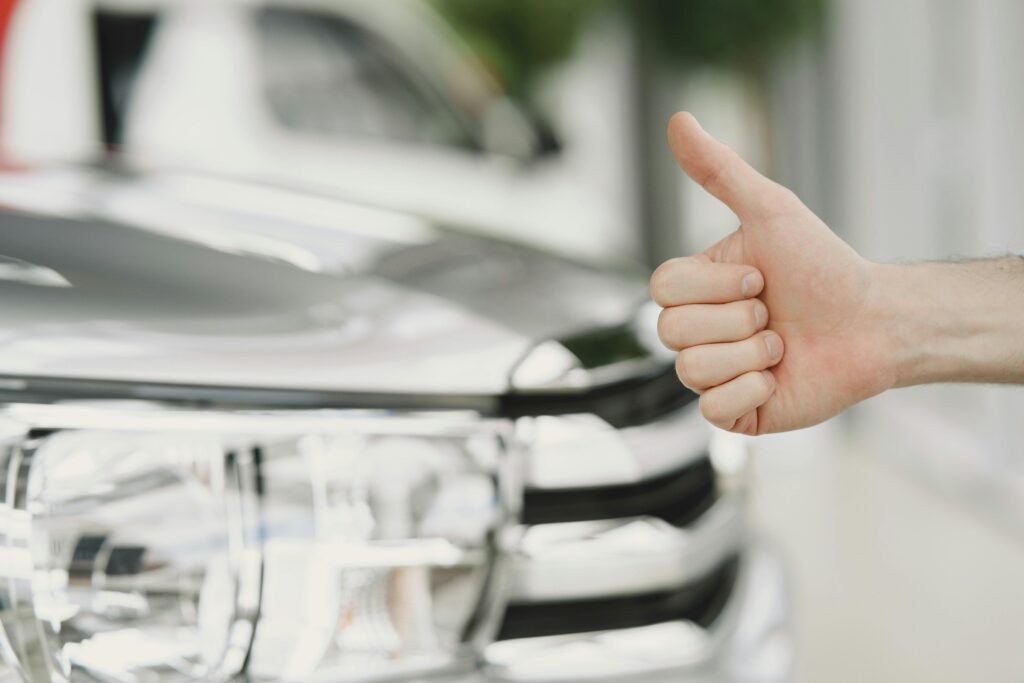 Happy customer showing a thumbs up from being approved for a car loan with low or no credit.